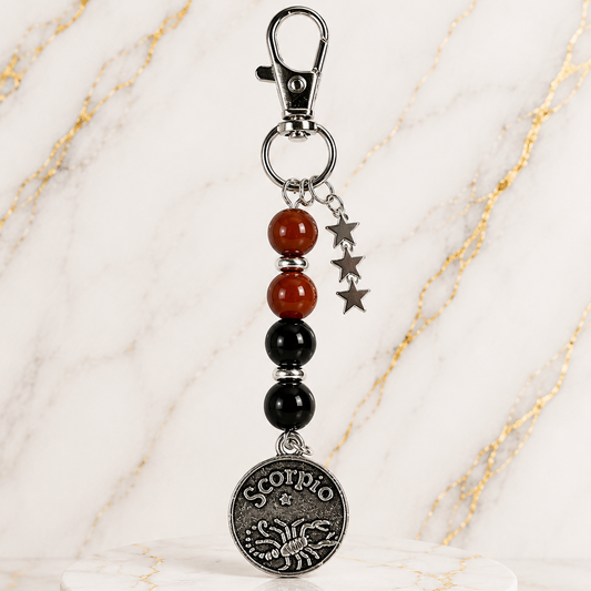 Keychain with beads and Scorpio pendant on a marble surface