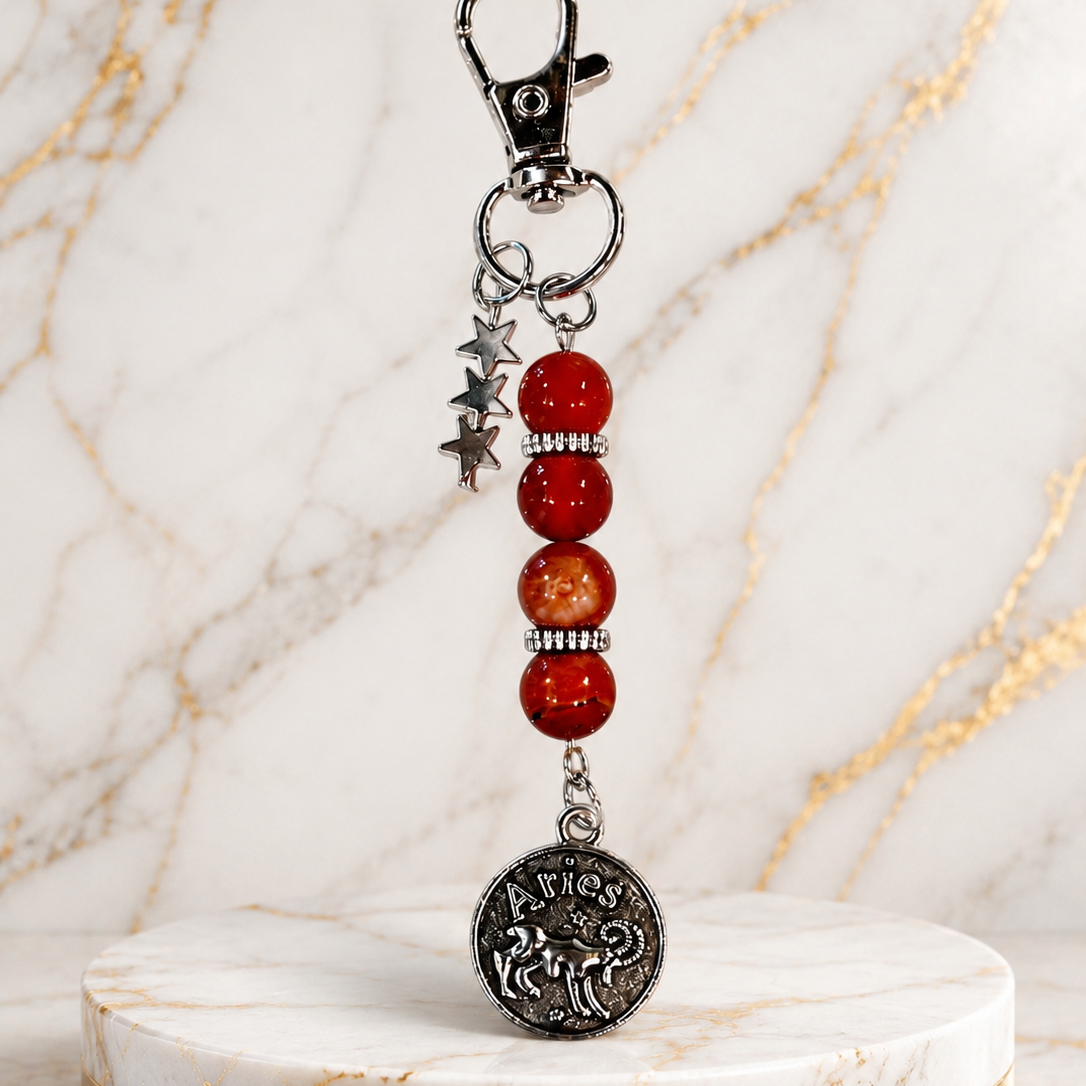 Keychain with beads and a coin charm on a marble background