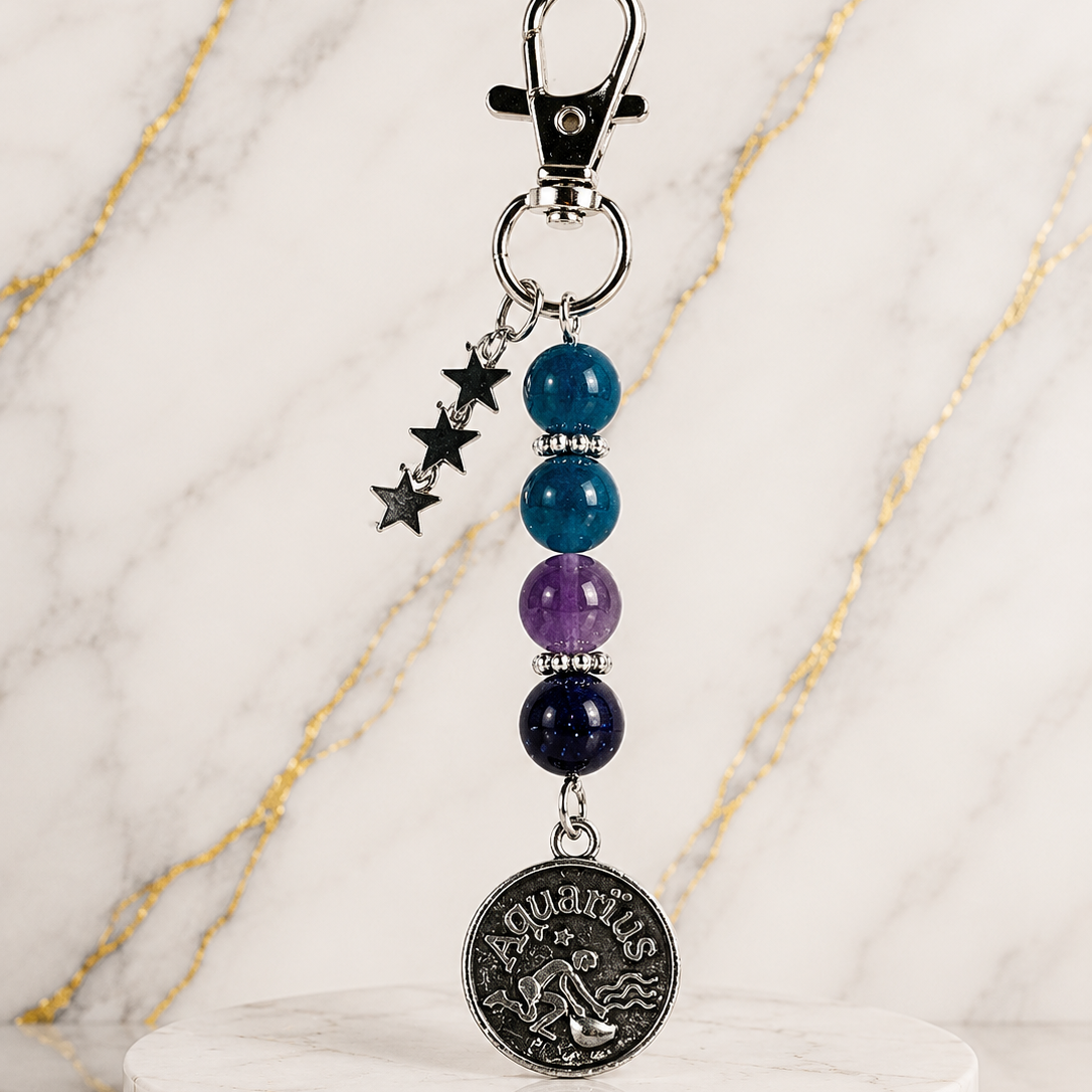 Keychain with beads and a zodiac charm on a marble stand