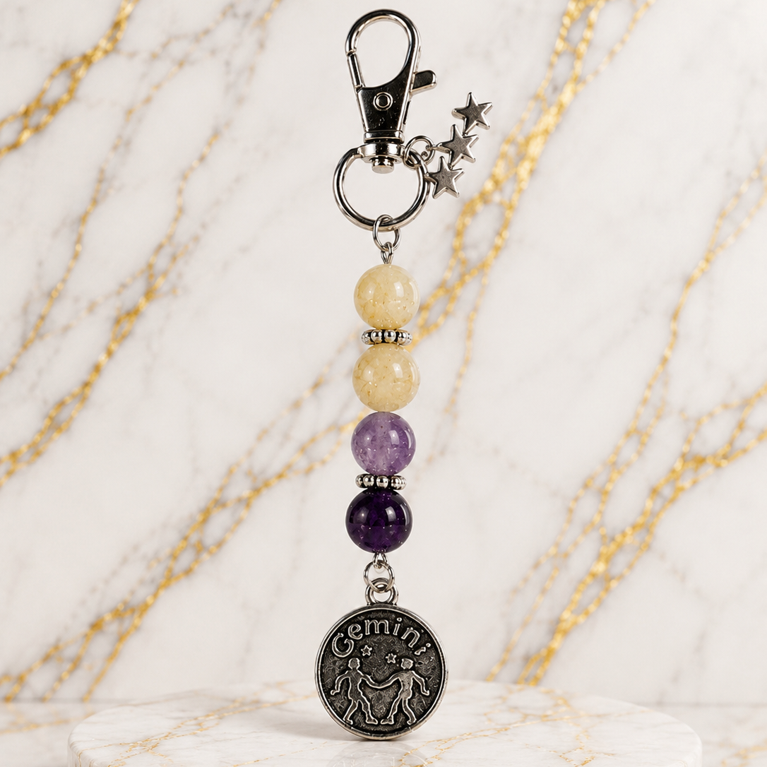 Keychain with gemstones and a Geminis charm on a marble base